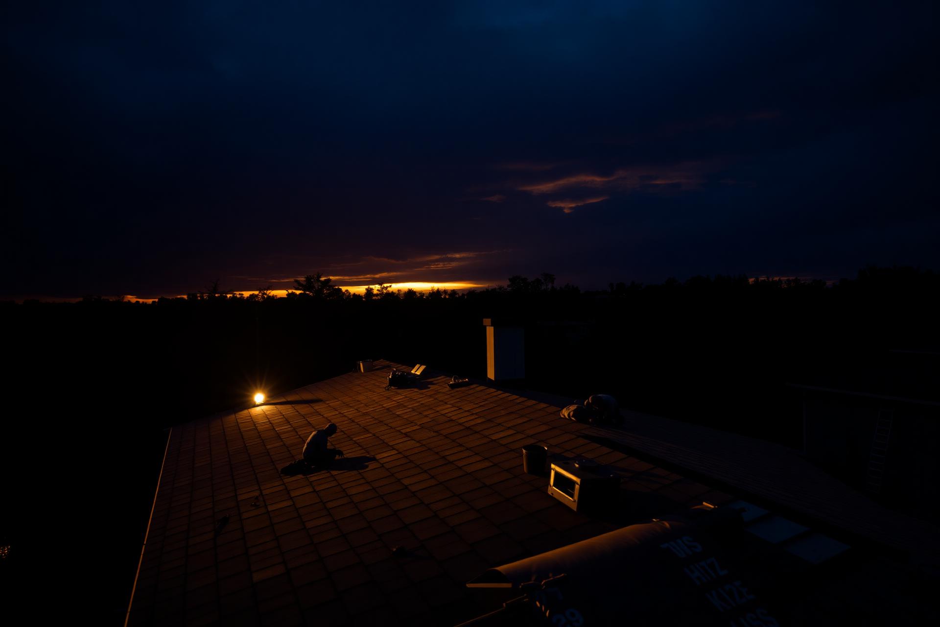 Roofing crew on the job at sunset
